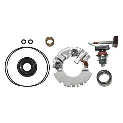 metal starter motor brush holder kit with springs, seals, bearings, and carbon brushes on white background
