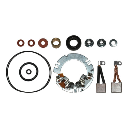 Various motor repair parts including washers, nuts, bushings, brushes, o-rings, and a metal mounting plate on white background